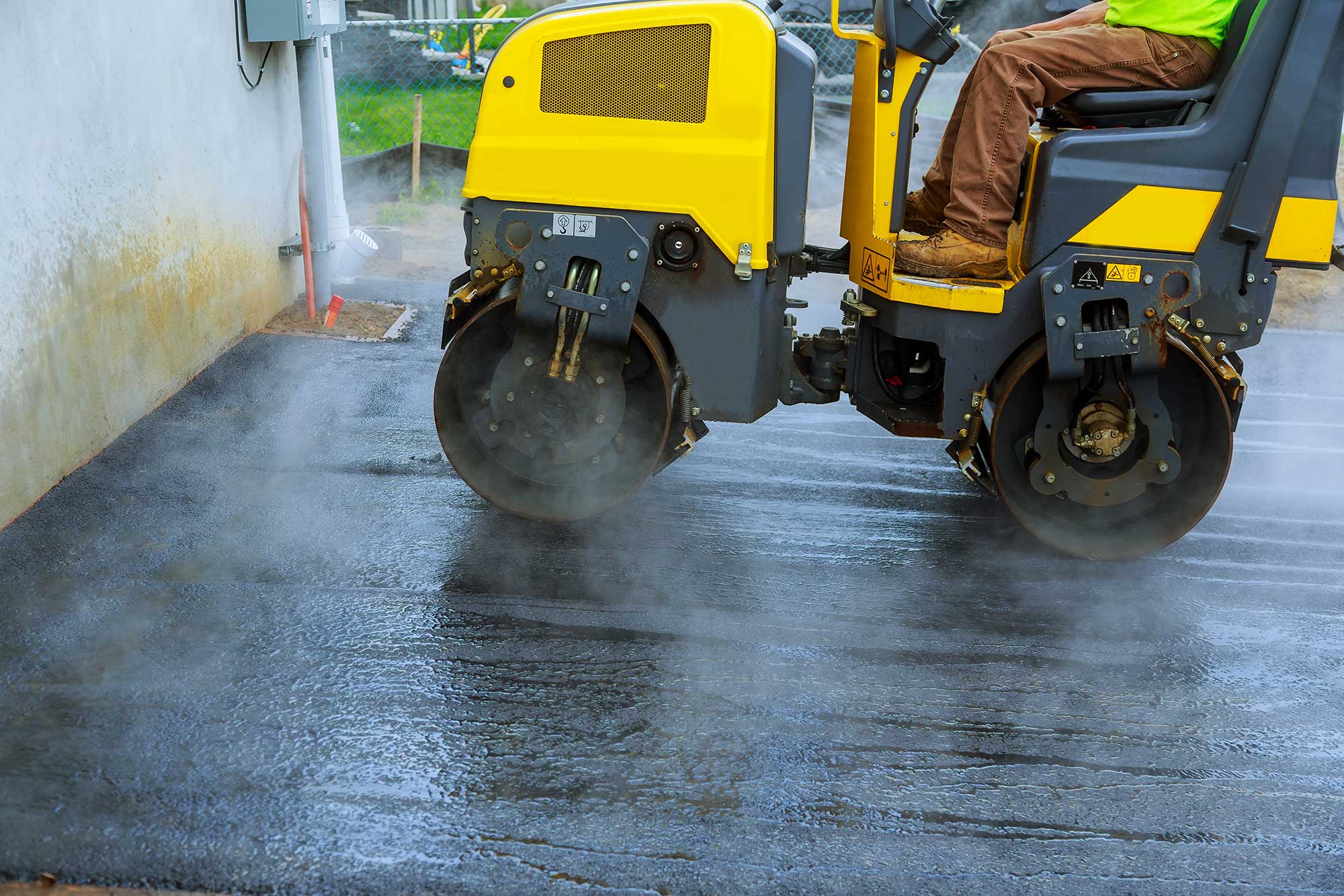 Cropped image of an experienced paving contractor working on a residential driveway/parking lot.