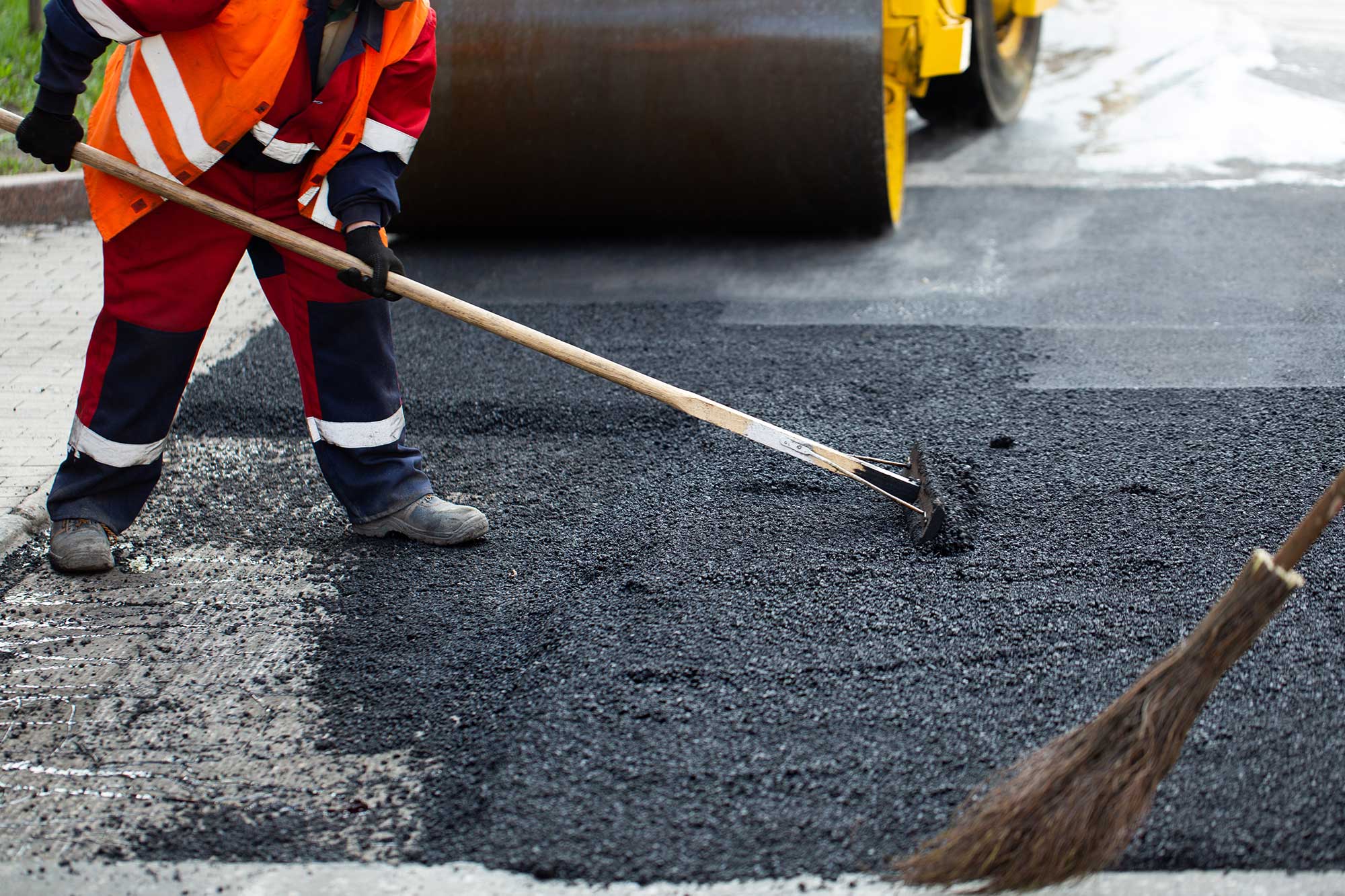 Paving contractor applying high-quality asphalt for a durable road surface.