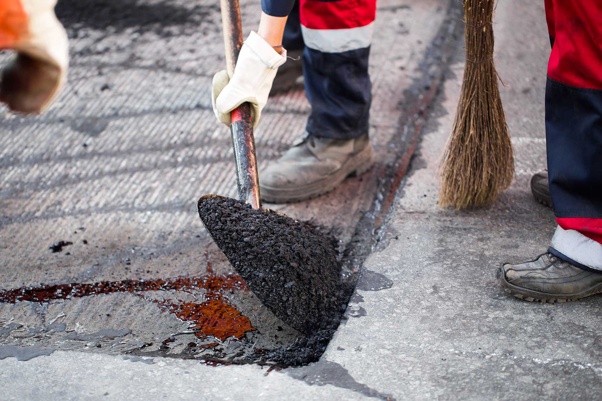 A pile of recycled asphalt in front of a construction truck, ready for use in a paving project.