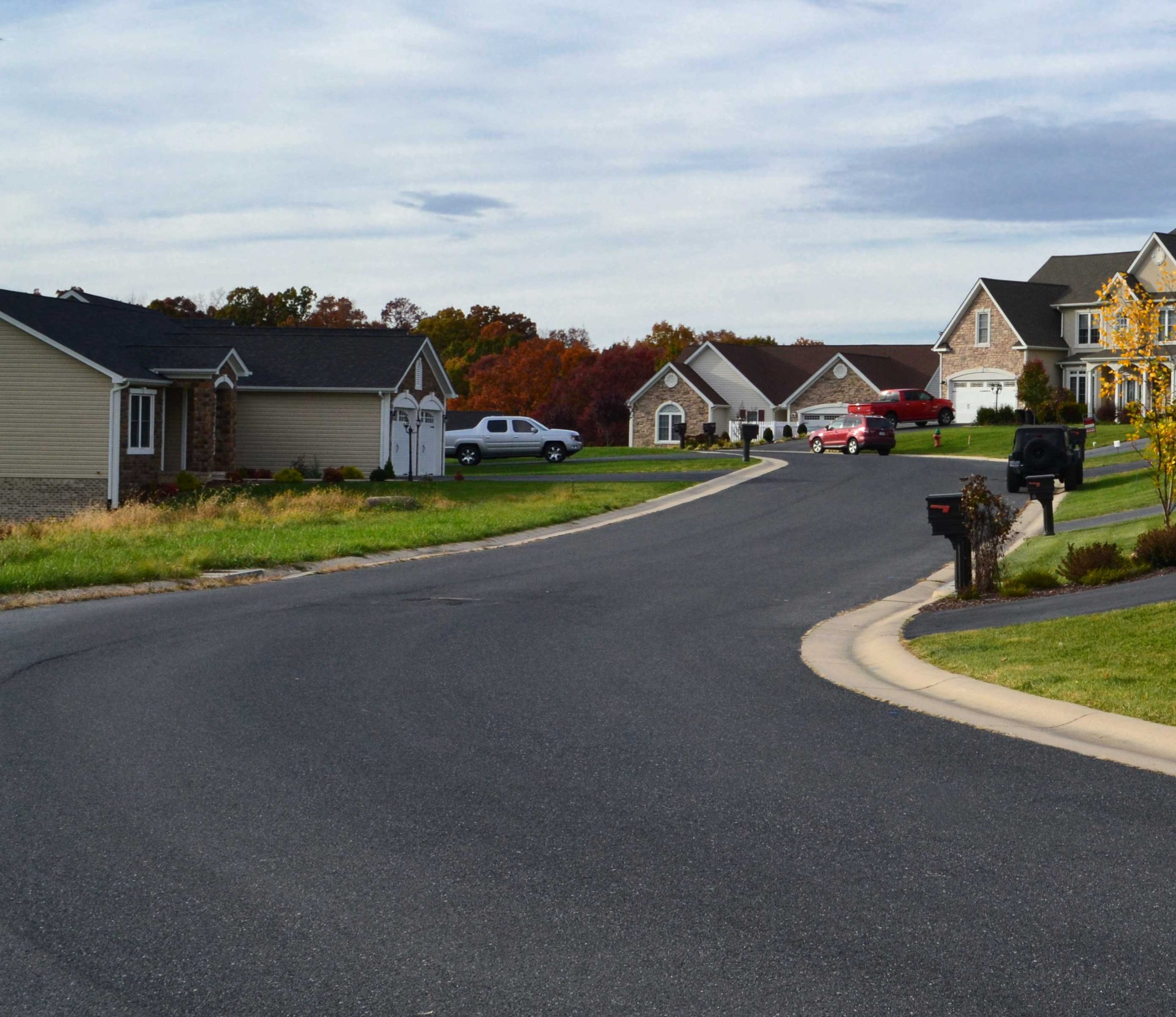 A newly completed residential paving project with a smooth asphalt driveway.